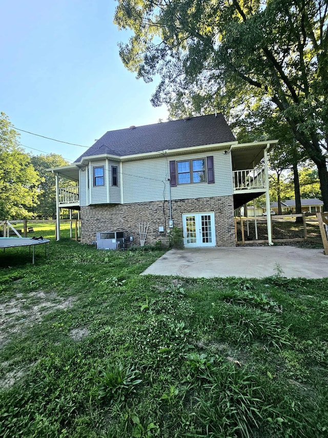 102 Hazelnut Ave, Camden, TN 38320 - rear view of property featuring a trampoline, a patio area, a yard, and stone siding