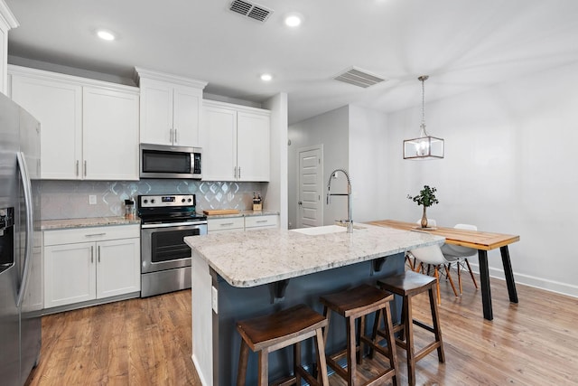 2717 Gossett Trl, Nashville, TN 37221 - kitchen featuring stainless steel appliances, a sink, light wood-style flooring, backsplash, and recessed lighting
