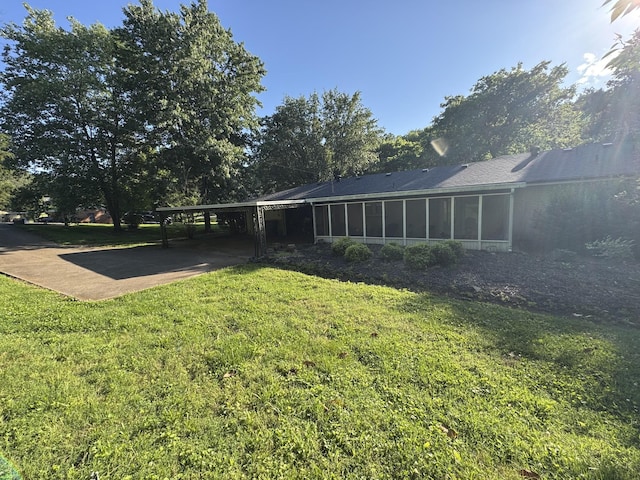 512 Utley Dr, Goodlettsville, TN 37072 - view of grassy yard featuring a carport, a sunroom, and concrete driveway
