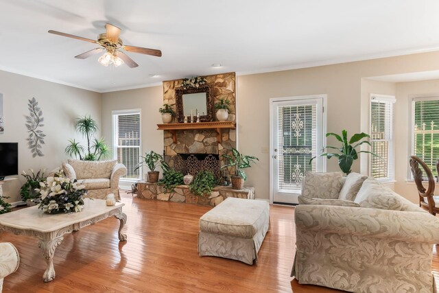 3871 Stevens Ln, Nashville, TN 37218 - living area featuring light wood finished floors, a ceiling fan, a stone fireplace, and ornamental molding