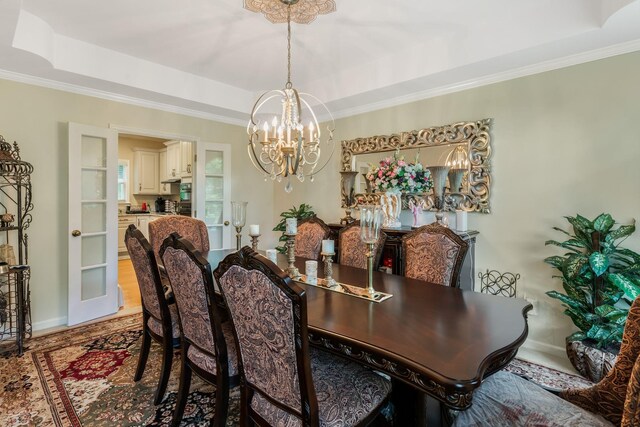 3871 Stevens Ln, Nashville, TN 37218 - dining area featuring a tray ceiling, a chandelier, baseboards, ornamental molding, and light wood finished floors