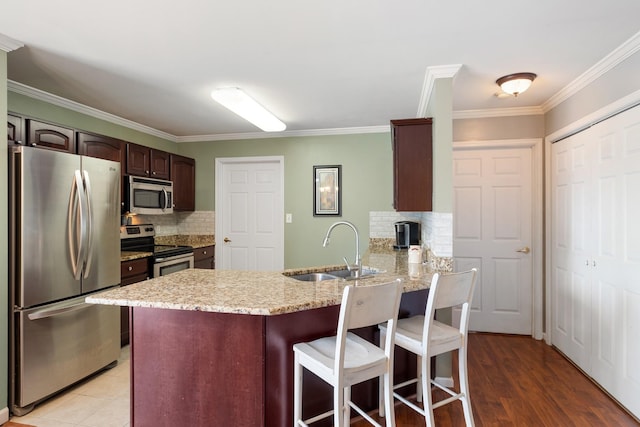102 Mckinley Dr, Columbia, TN 38401 - kitchen featuring stainless steel appliances, a sink, a peninsula, decorative backsplash, and ornamental molding