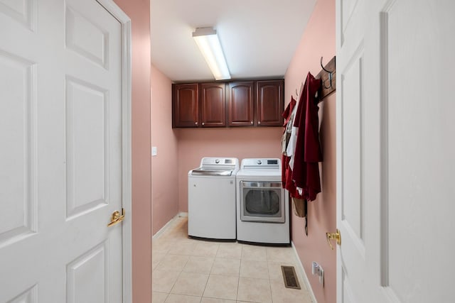 102 Mckinley Dr, Columbia, TN 38401 - laundry area featuring cabinet space, washer and dryer, light tile patterned floors, and baseboards