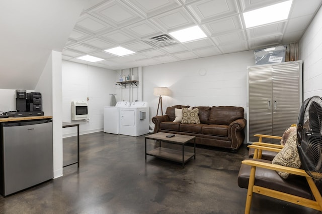 2890 Ellis Ln, Palmyra, TN 37142 - living area with heating unit, finished concrete flooring, independent washer and dryer, and concrete block wall