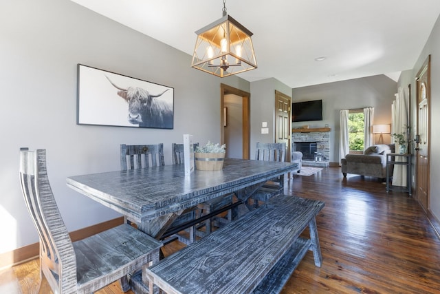 2890 Ellis Ln, Palmyra, TN 37142 - dining area featuring wood finished floors, a chandelier, a fireplace, and baseboards