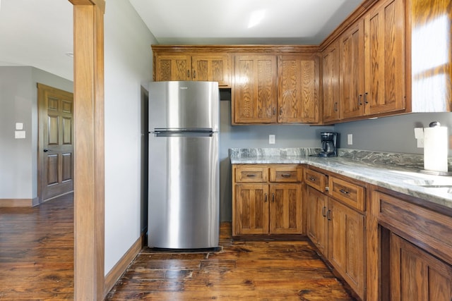2890 Ellis Ln, Palmyra, TN 37142 - kitchen with freestanding refrigerator, brown cabinetry, and dark wood-type flooring