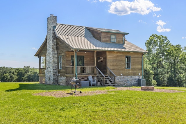 2890 Ellis Ln, Palmyra, TN 37142 - view of front of house with covered porch, a front yard, a chimney, cooling unit, and metal roof