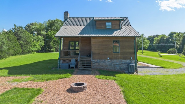 2890 Ellis Ln, Palmyra, TN 37142 - back of house featuring a fire pit, a yard, a chimney, and covered porch
