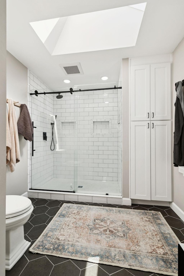 519 Glen Echo Dr, Old Hickory, TN 37138 - full bath featuring a stall shower, toilet, tile patterned flooring, a skylight, and recessed lighting