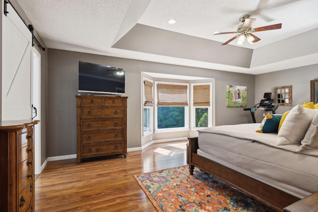 519 Glen Echo Dr, Old Hickory, TN 37138 - bedroom featuring wood finished floors, baseboards, a barn door, a tray ceiling, and recessed lighting