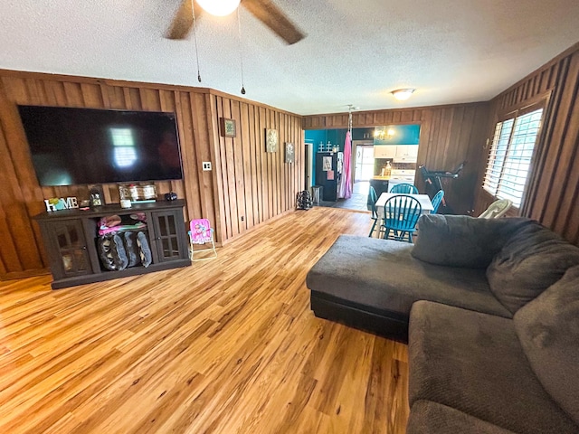 126 Carroll St S, Bruceton, TN 38317 - living room featuring a textured ceiling, wood finished floors, ceiling fan, and wood walls