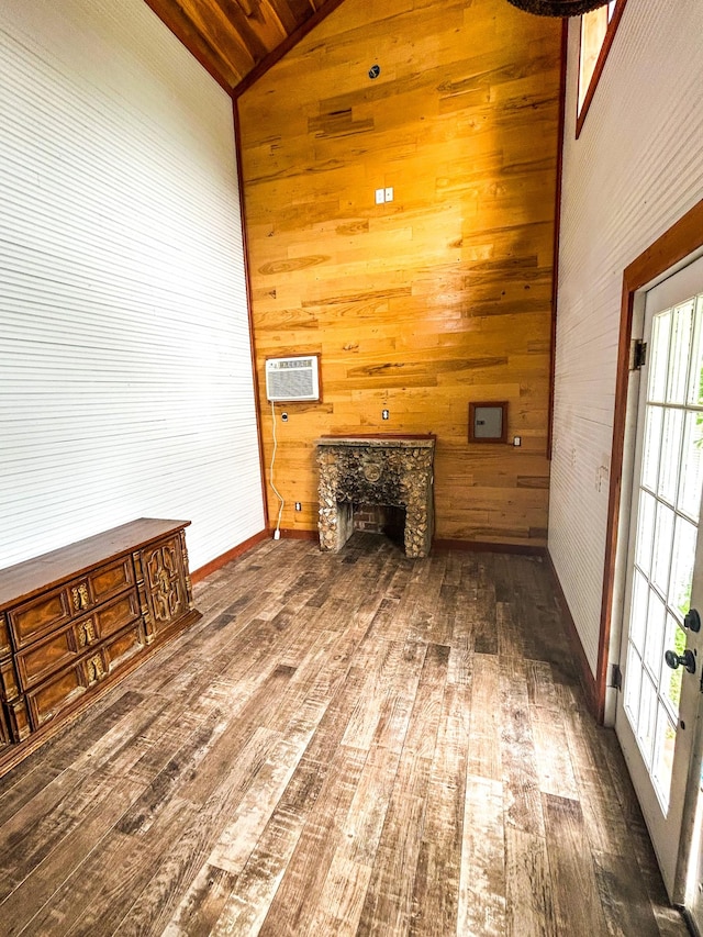 126 Carroll St S, Bruceton, TN 38317 - unfurnished living room featuring wooden walls, hardwood / wood-style floors, vaulted ceiling, plenty of natural light, and a wall unit AC