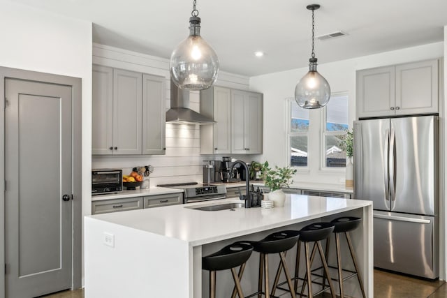 1609 Marsden Ave, Nashville, TN 37216 - kitchen featuring appliances with stainless steel finishes, gray cabinetry, light countertops, wall chimney range hood, and a center island with sink