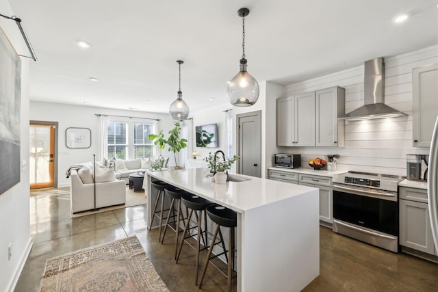 1609 Marsden Ave, Nashville, TN 37216 - kitchen featuring stainless steel electric range oven, wall chimney range hood, gray cabinetry, a breakfast bar area, and light countertops