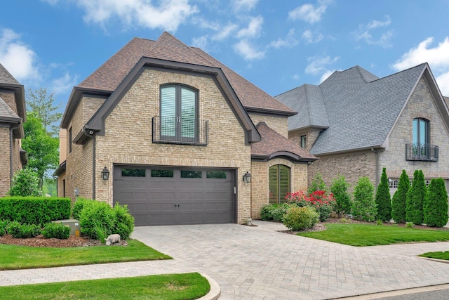 1161 Chloe Dr, Gallatin, TN 37066 - french country home featuring an attached garage, decorative driveway, roof with shingles, and brick siding