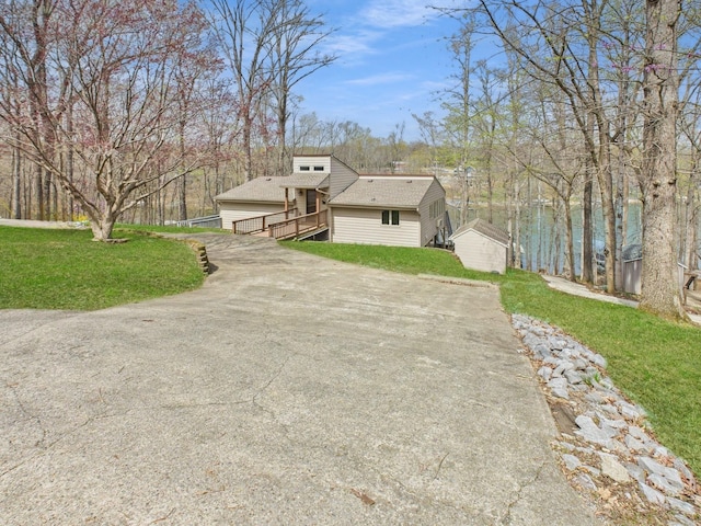 695 Bayshore Dr, Cadiz, KY 42211 - view of front of house featuring a front yard, concrete driveway, an outbuilding, and roof with shingles