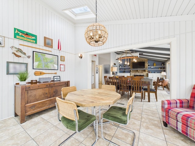 695 Bayshore Dr, Cadiz, KY 42211 - dining area with a chandelier, light tile patterned floors, a skylight, vaulted ceiling, and wood walls