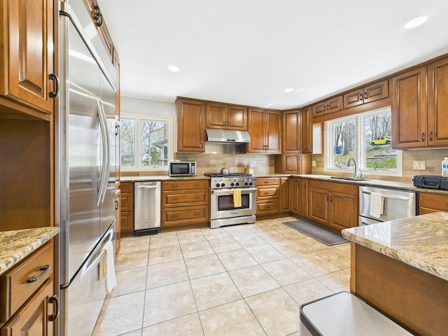 695 Bayshore Dr, Cadiz, KY 42211 - kitchen featuring premium appliances, under cabinet range hood, a sink, tasteful backsplash, and light stone counters