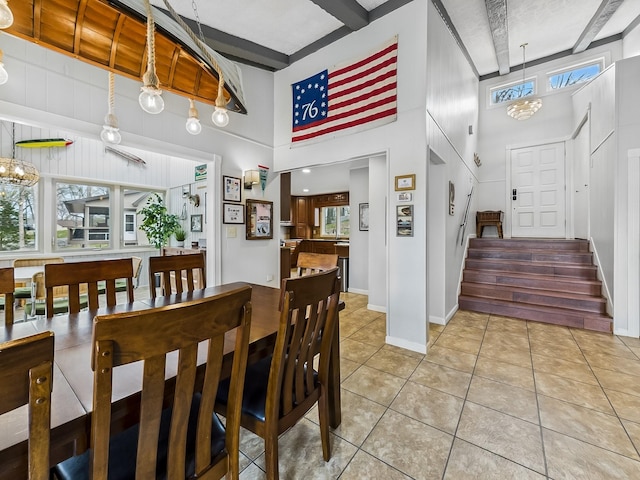 695 Bayshore Dr, Cadiz, KY 42211 - dining space with light tile patterned floors, a towering ceiling, stairway, baseboards, and beamed ceiling