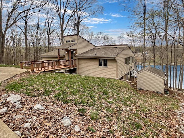 695 Bayshore Dr, Cadiz, KY 42211 - rear view of house with roof with shingles, a deck with water view, and a lawn