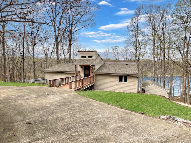 695 Bayshore Dr, Cadiz, KY 42211 - mid-century modern home with a shingled roof, a wooden deck, a front lawn, and driveway
