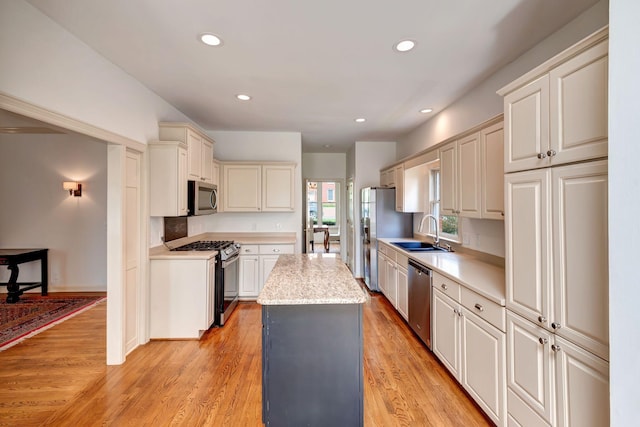 213 Andover Way, Nashville, TN 37221 - kitchen featuring appliances with stainless steel finishes, light countertops, a sink, a center island, and light wood-style floors