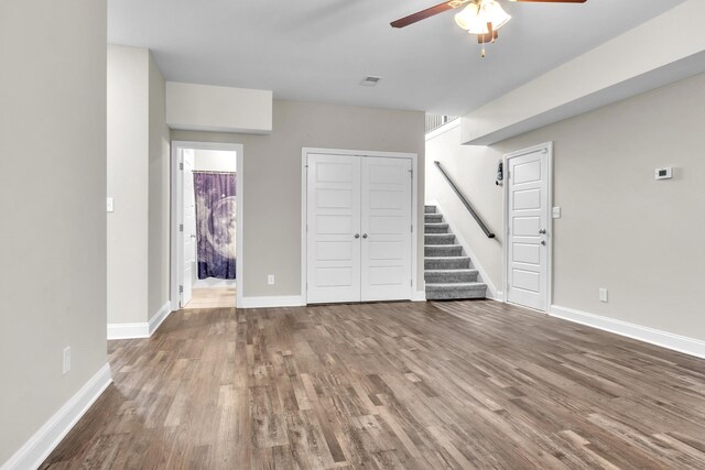 1928 Sydney Louise Dr, Clarksville, TN 37042 - unfurnished living room featuring ceiling fan, wood finished floors, stairway, and baseboards