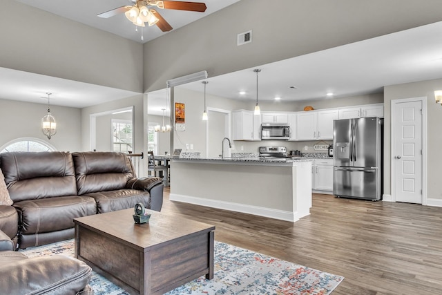 1928 Sydney Louise Dr, Clarksville, TN 37042 - living room featuring ceiling fan, light wood-type flooring, a chandelier, baseboards, and recessed lighting
