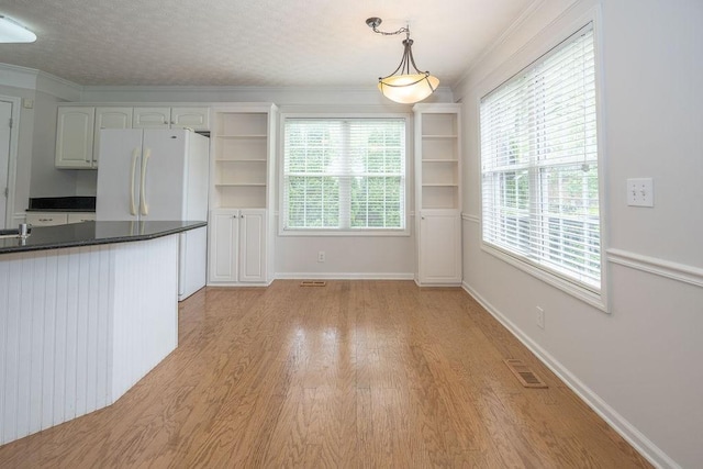2818 Crazy Horse, Murfreesboro, TN 37127 - kitchen featuring freestanding refrigerator, dark countertops, light wood-style flooring, pendant lighting, and open shelves