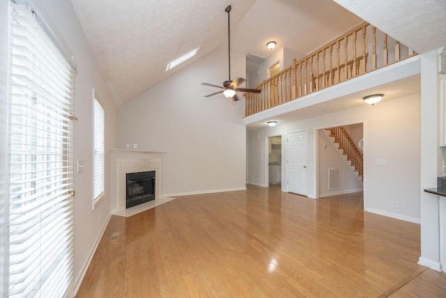 2818 Crazy Horse, Murfreesboro, TN 37127 - unfurnished living room with a high end fireplace, a ceiling fan, light wood-style floors, stairs, and a textured ceiling