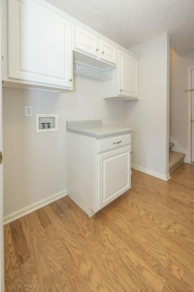 2818 Crazy Horse, Murfreesboro, TN 37127 - washroom with hookup for a washing machine, baseboards, cabinet space, light wood-type flooring, and a textured ceiling
