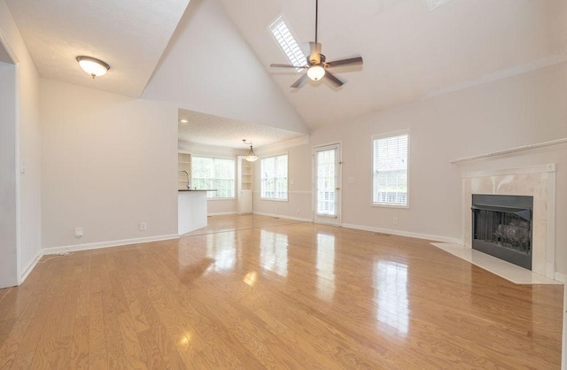 2818 Crazy Horse, Murfreesboro, TN 37127 - unfurnished living room with a premium fireplace, ceiling fan, high vaulted ceiling, wood finished floors, and baseboards