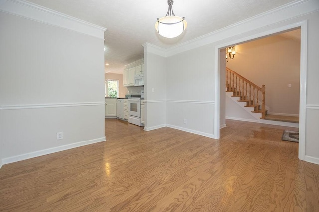 2818 Crazy Horse, Murfreesboro, TN 37127 - spare room featuring light wood-style floors, crown molding, stairway, and baseboards