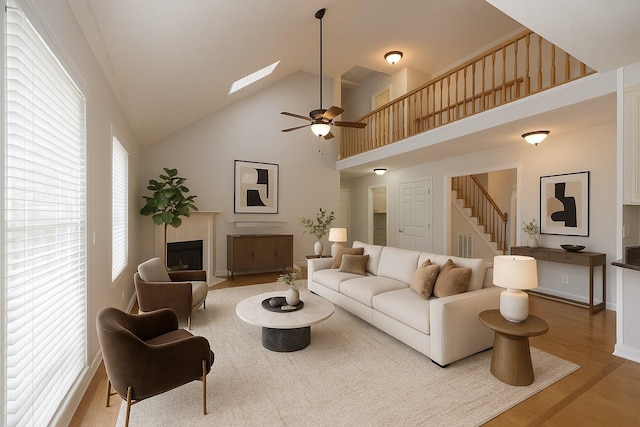 2818 Crazy Horse, Murfreesboro, TN 37127 - living room featuring wood finished floors, stairs, a fireplace with flush hearth, high vaulted ceiling, and baseboards