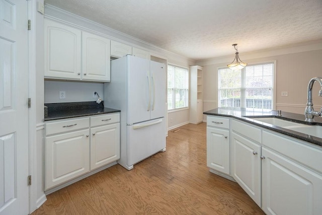 2818 Crazy Horse, Murfreesboro, TN 37127 - kitchen featuring freestanding refrigerator, a sink, dark countertops, light wood-style floors, and white cabinetry