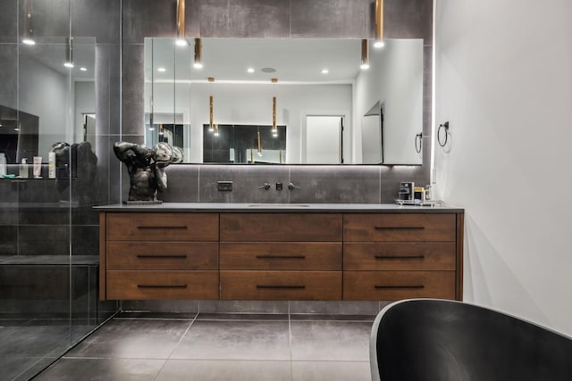 1016B 9th Ave S, Nashville, TN 37203 - bathroom featuring double vanity, tiled shower, decorative backsplash, and tile patterned flooring