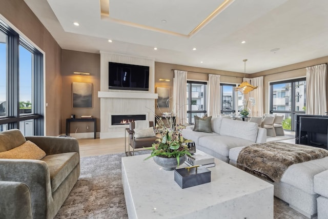 1016B 9th Ave S, Nashville, TN 37203 - living room with a large fireplace, wood finished floors, a tray ceiling, and recessed lighting