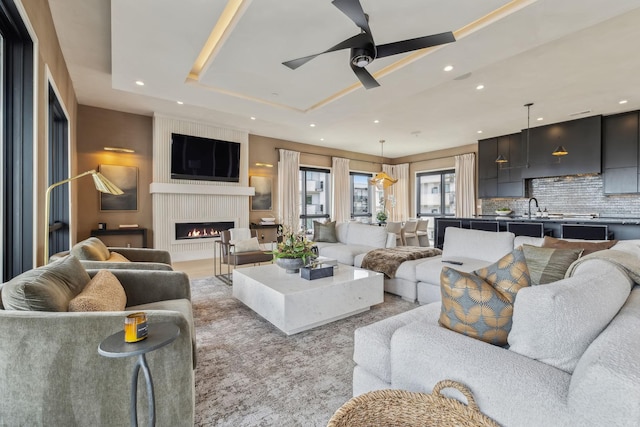 1016B 9th Ave S, Nashville, TN 37203 - living room featuring a tray ceiling, a large fireplace, a ceiling fan, and recessed lighting