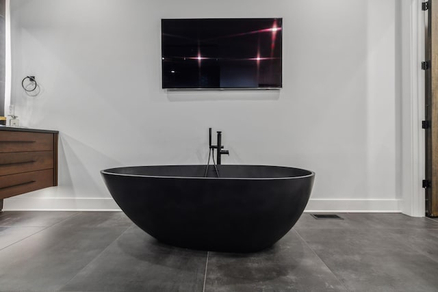 1016B 9th Ave S, Nashville, TN 37203 - detailed view of concrete flooring, vanity, a freestanding tub, and baseboards