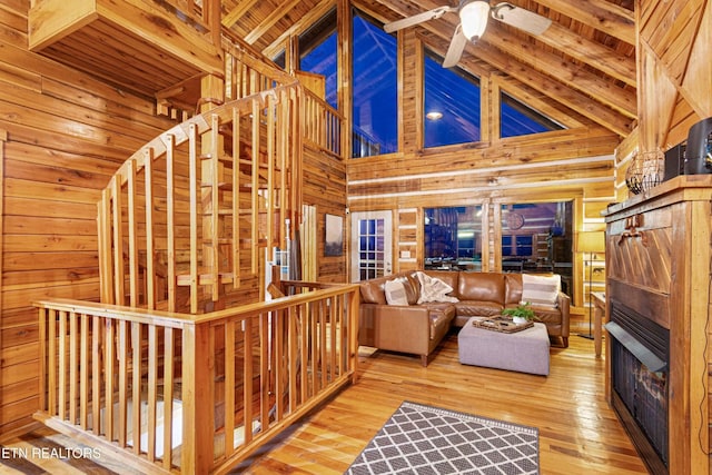 1815 Silver Poplar Ln, Sevierville, TN 37876 - living room with wood walls, hardwood / wood-style floors, high vaulted ceiling, a fireplace, and beamed ceiling