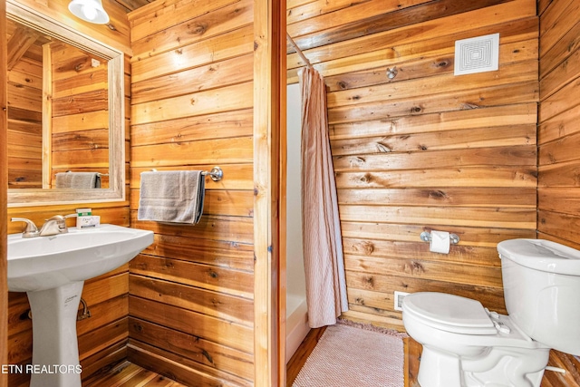 1815 Silver Poplar Ln, Sevierville, TN 37876 - bathroom with toilet, wooden walls, shower / tub combo, and a sink