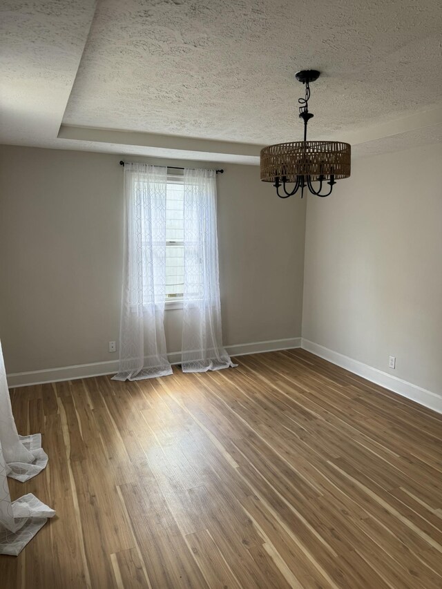1210 Daniel St, Clarksville, TN 37040 - unfurnished room featuring baseboards, wood finished floors, a chandelier, and a textured ceiling