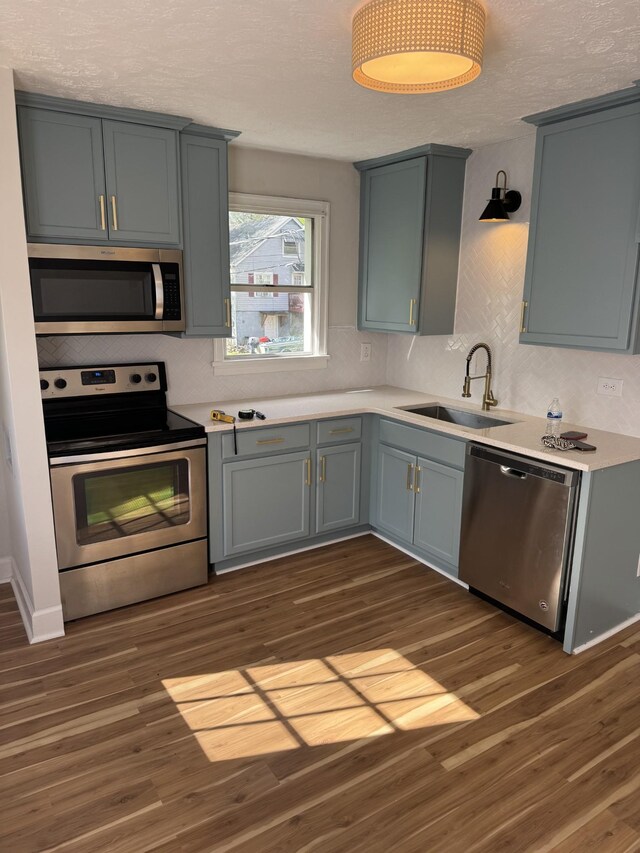 1210 Daniel St, Clarksville, TN 37040 - kitchen with appliances with stainless steel finishes, a sink, dark wood-type flooring, light countertops, and a textured ceiling