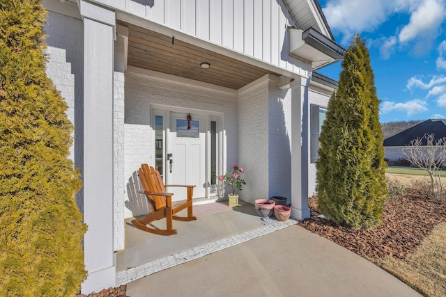 163 Autumn Wind Dr SW, Cleveland, TN 37311 - property entrance featuring board and batten siding, brick siding, and covered porch