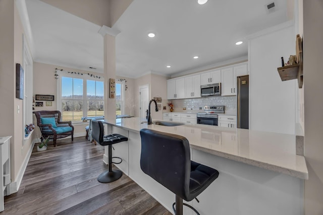 163 Autumn Wind Dr SW, Cleveland, TN 37311 - kitchen with stainless steel appliances, white cabinets, tasteful backsplash, a breakfast bar area, and recessed lighting