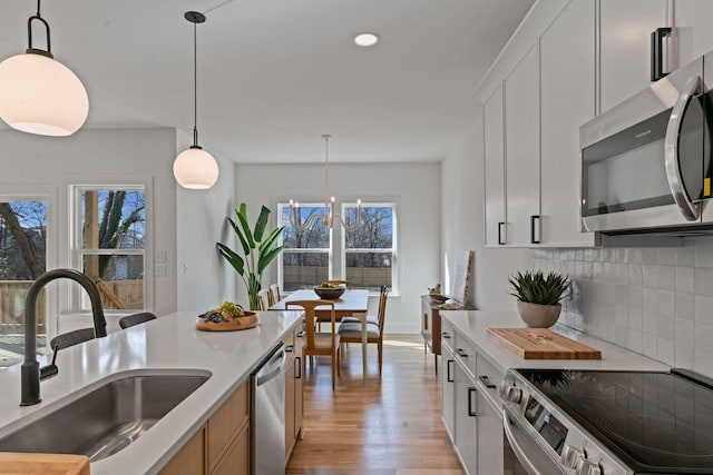 534 Green Ln, Whites Creek, TN 37189 - kitchen with appliances with stainless steel finishes, a sink, light wood-style floors, backsplash, and light countertops
