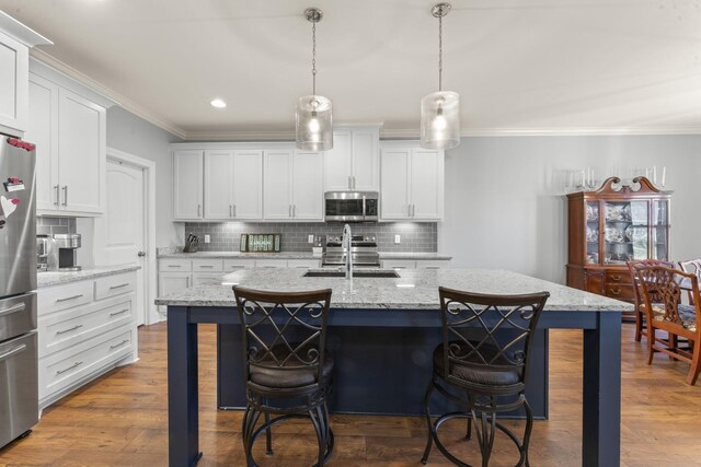 4115 Andes Dr, Murfreesboro, TN 37127 - kitchen with stainless steel appliances, a sink, decorative backsplash, ornamental molding, and a breakfast bar