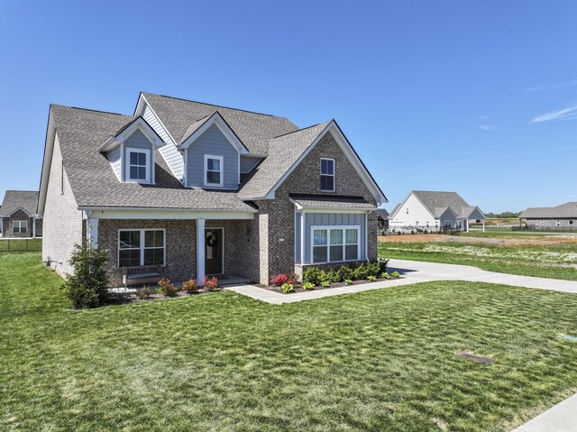 4115 Andes Dr, Murfreesboro, TN 37127 - view of front facade with a front yard, brick siding, a shingled roof, and a porch