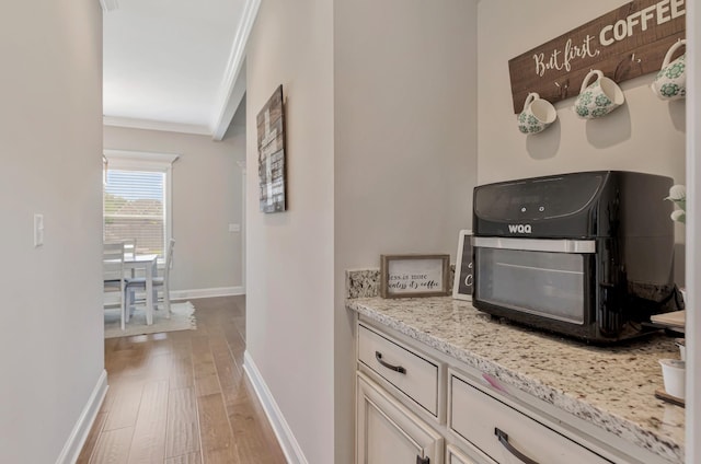 1114 Escalade Ct, Lascassas, TN 37085 - kitchen featuring crown molding, baseboards, wood finished floors, light stone countertops, and white cabinets