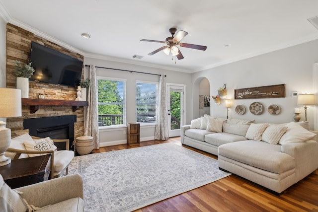 3324 Redmon Hl, Nolensville, TN 37135 - living area with ceiling fan, wood finished floors, a stone fireplace, arched walkways, and ornamental molding